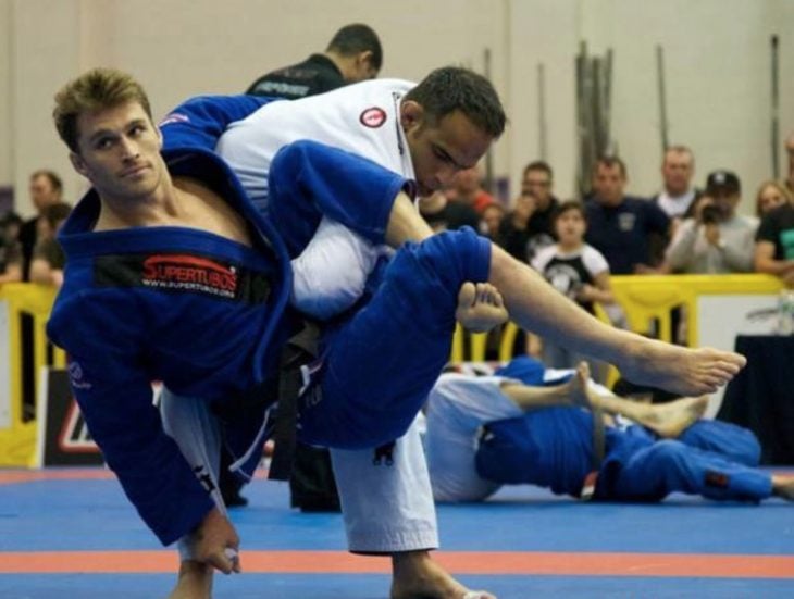 Un hombre en un combate de Tae Kwan Do está a punto de ser derribado pero se ve tranquilo y muy fotogénico