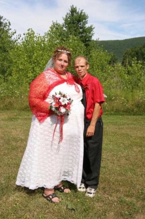 Novia usando un vestido de novia con un chal rojo arriba y sandalias negras