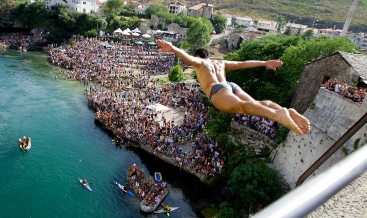 Hombre aventándose del Puente Viejo en Bosnia, clavadista