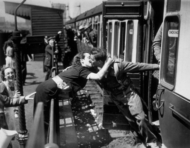 Amor en tiempos de guerra. mujer brinca la cerca para besar a un soldado que sale del tren