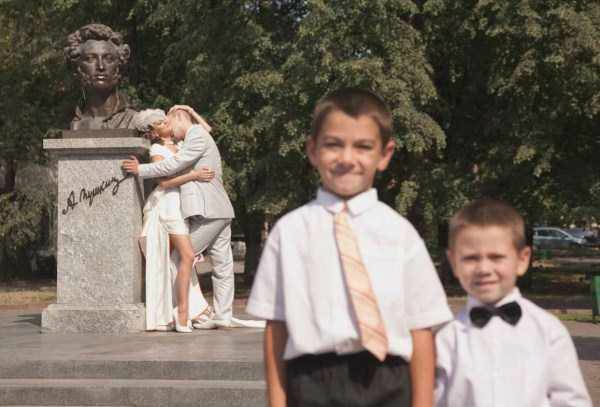 Pareja besándose atrás de niños