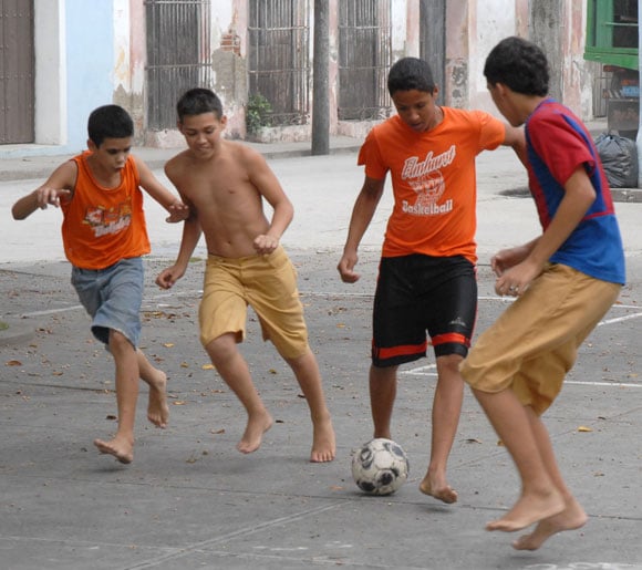 Niños jugando futbol en calle