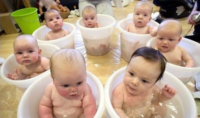 grupo de bebes bañandose en cubetas