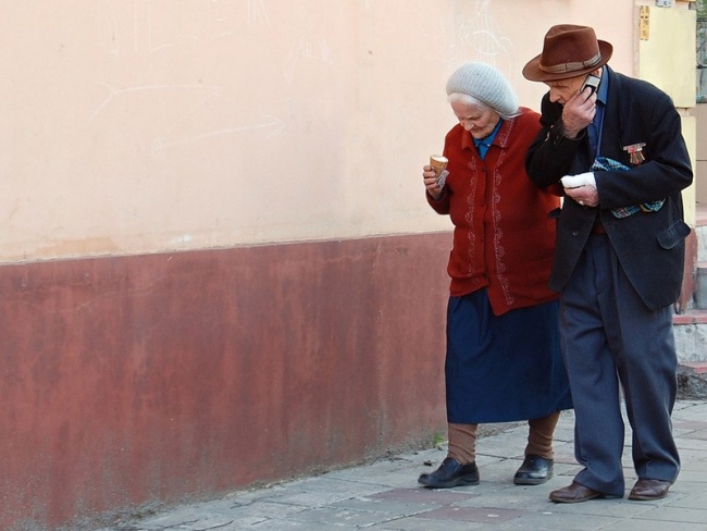 pareja de ancianos caminando y comiendo un helado