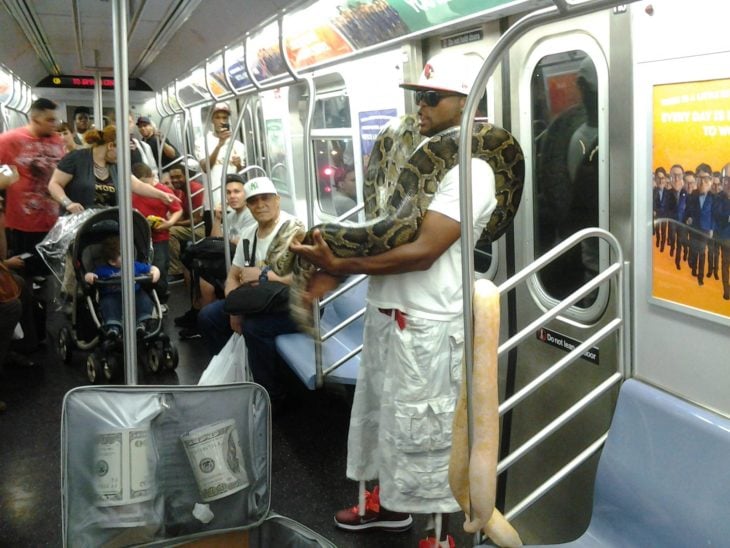 hombre viajando con unas serpientes en el metro