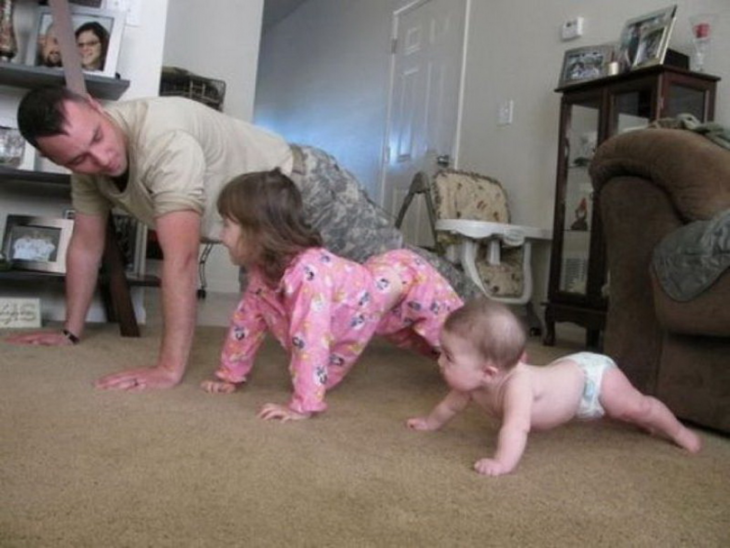 Papá haciendo ejercicio con sus dos hijas