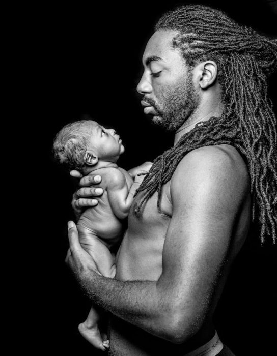 PAPÁ CON RASTAS EN UNA SESIÓN FOTOGRÁFICA CON SU BEBÉ