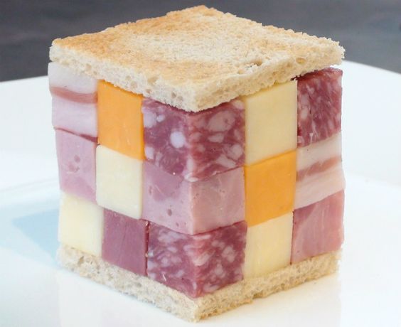 Sandwiches extraños. Sandwich con el queso, el jamón y el tocino cortados en cubos