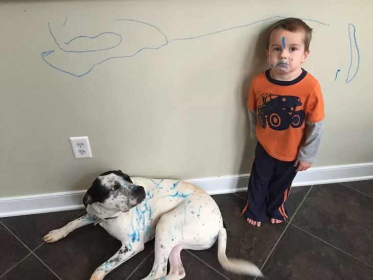 Niño con perro pintado con plumon azul