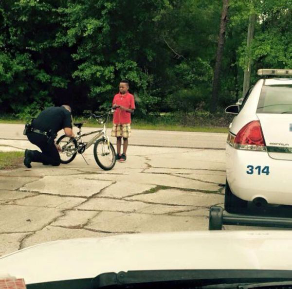 policia arreglando bicicleta de niño