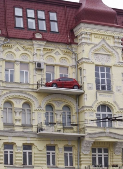 Fotos sin explicación. Un carro estacionado en el balcón del último piso de un edificio