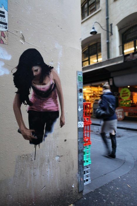 Graffitti de una mujer pintándose a si misma