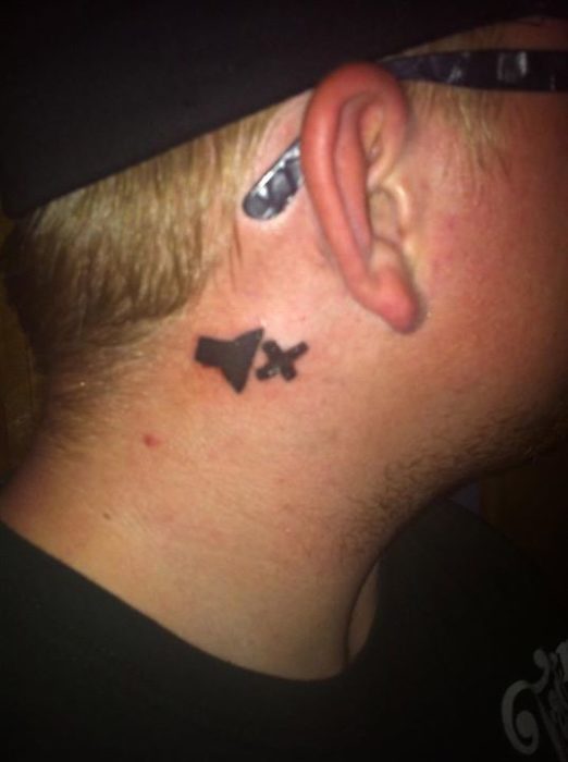 Tatuaje de un hombre sordo de una bocina con una tachita detrás de su oreja 