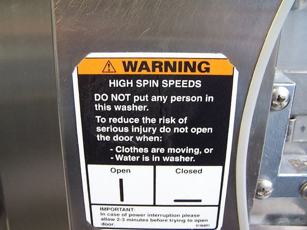 Advertencia de una lavadora que dice que no se debe echar a personas en ella