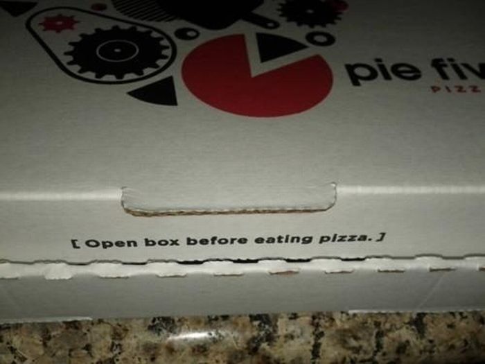 Letrero en la caja de la pizza que dice que se tiene que abrir primero la caja antes de comerse la pizza