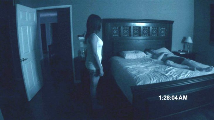 Mujer de pie junto a cama en habitación