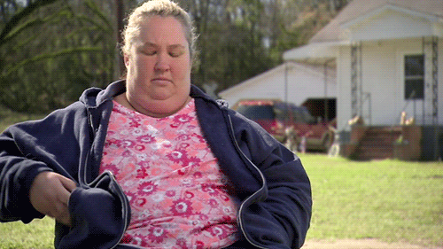 Mujer obesa sentada en un jardín, checando su celular