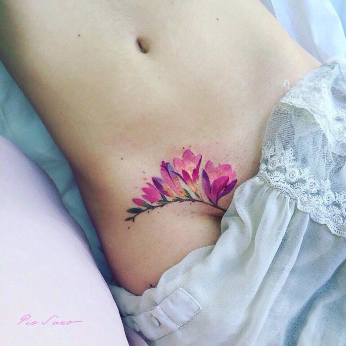 flor en la cadera de mujer tatuada