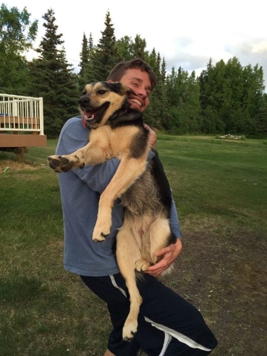 hombre cargando un perro