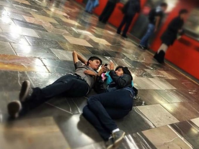 jovenes acostados mientras esperan el metro