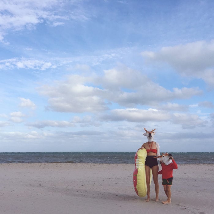 personas con cabezas de ciervo en la playa