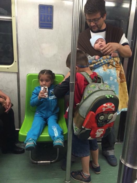 hombre con sus hijos en el metro