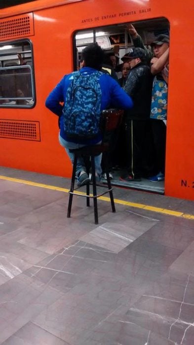 persona carga su propio asiento al metro