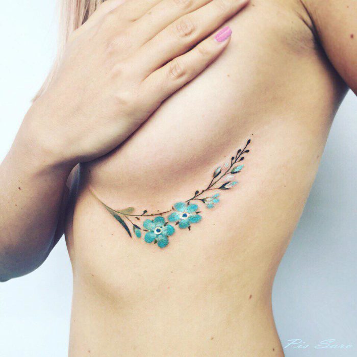 tatuaje de flores bajo un seno
