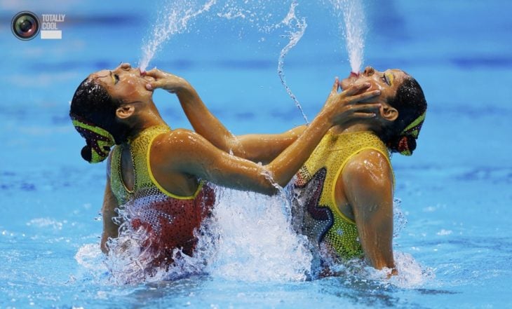 mujeres escupiendo agua