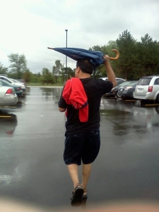 Hombre con paraguas sin abrir