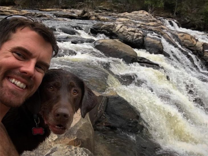 Selfie de hombre y su perra en una cascada