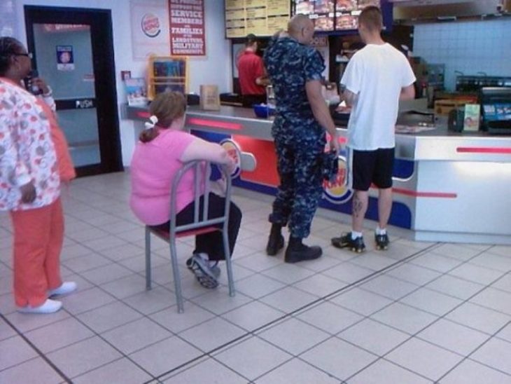 Mujer en la fila de burger king sentada en una silla