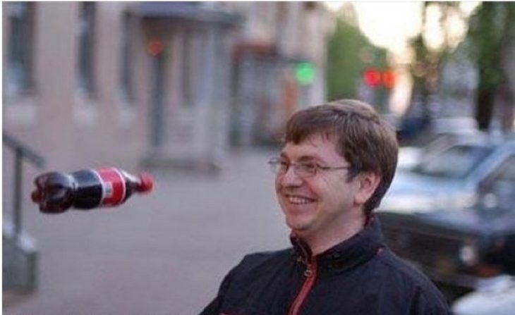 hombre sonrie mientras le arrojan una coca a la cara