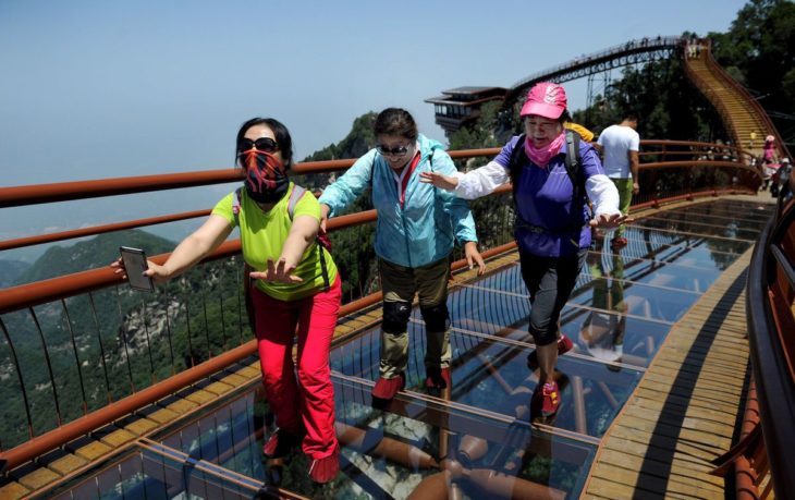 muchos turistas en un puente de vidrio