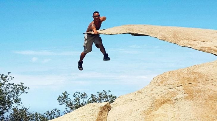 hombre apoyándose en una roca