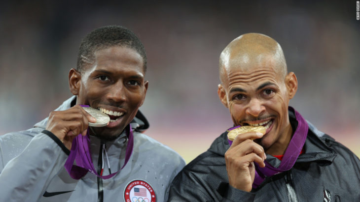 dos atletas mordiendo sus medallas