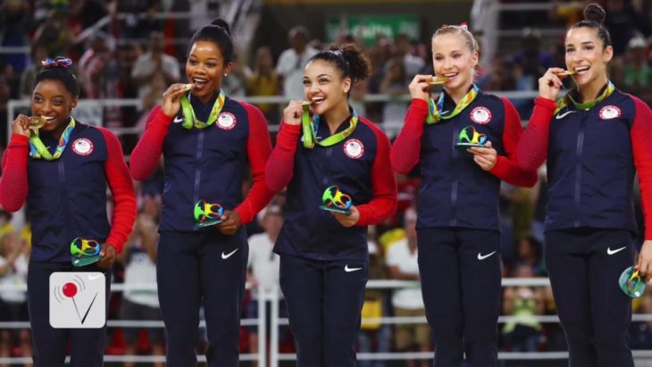 equipo femenino mordiendo medallas olímpicas 