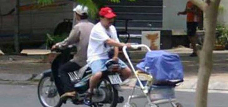 señor en moto con la carreola de su hijo