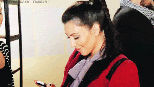 Kim Kardashian riendose con el celular