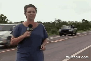 Reportera en vivo en la calle justo cuando pasa un tráiler muy cerca de ella