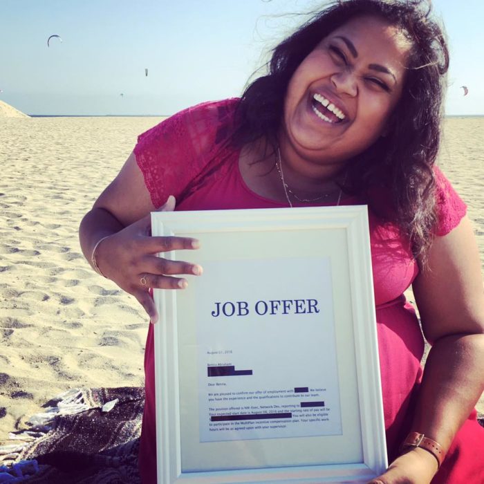 Benita Abraham feliz sosteniendo su oferta de trabajo