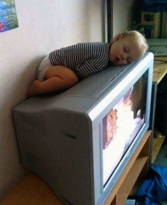 Niño dormido sobre televisión
