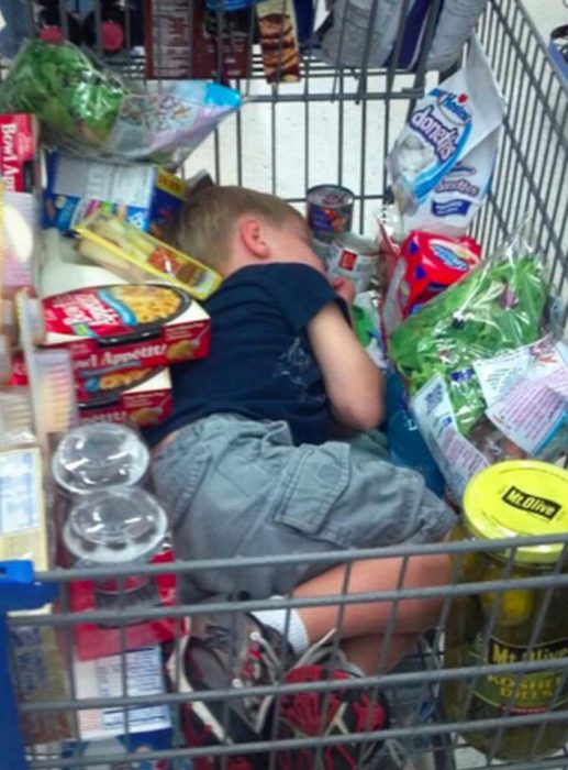 Niño dormido en el carrito del super