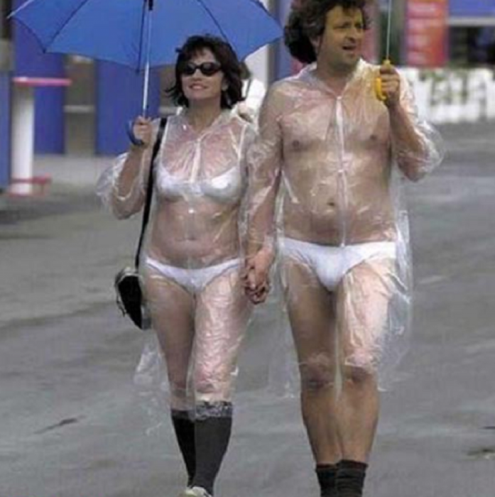 Hombre y mujer paseandose en ropa interior con calcetas y un impermeable trasparente
