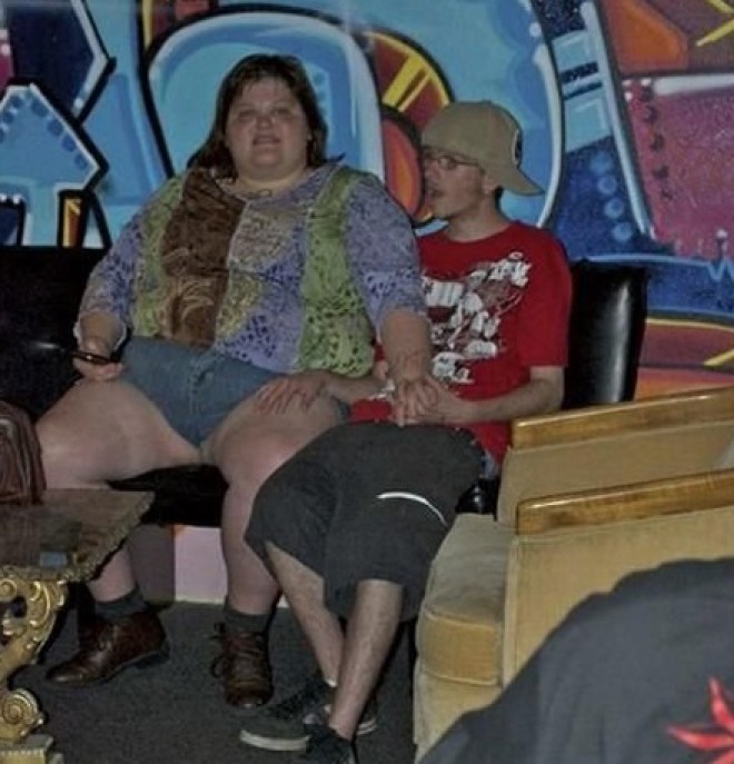 Mujer con obesidad con un mini short con joven flaquito tocandole la pierna