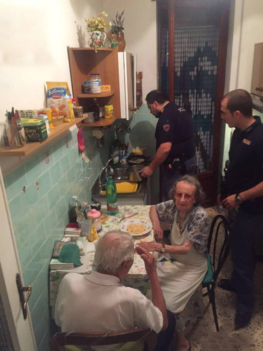 Dos policias en la cocina con una pareja de ancianos