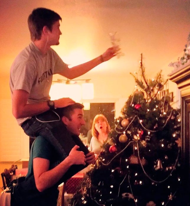 hermanos jóvenes poniendo el árbol de navidad