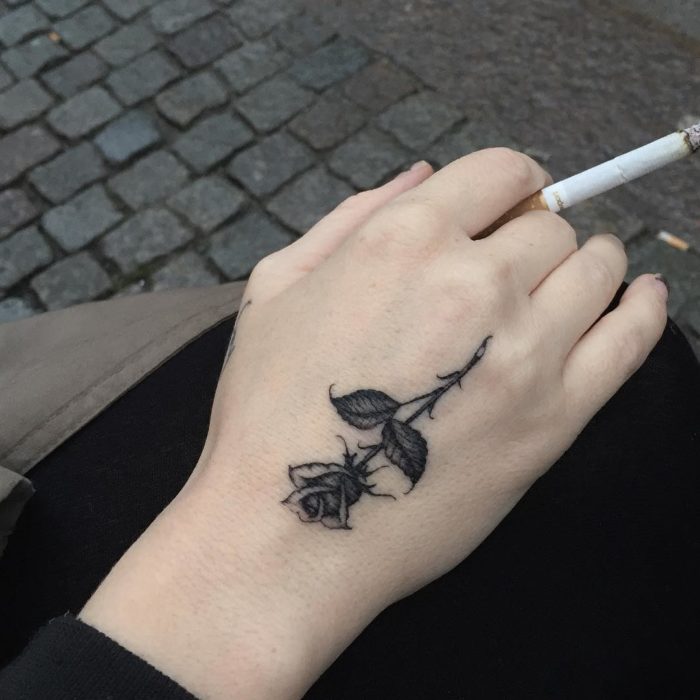 tatuaje de una rosa en la mano