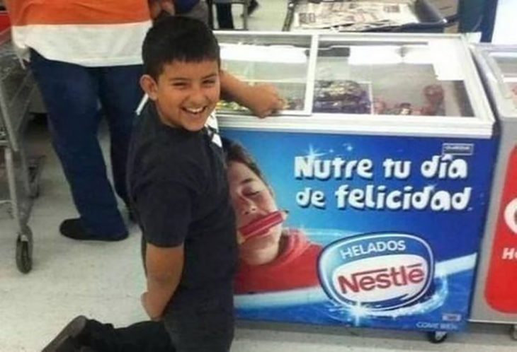 niño hincado frente a refrigerador de helados