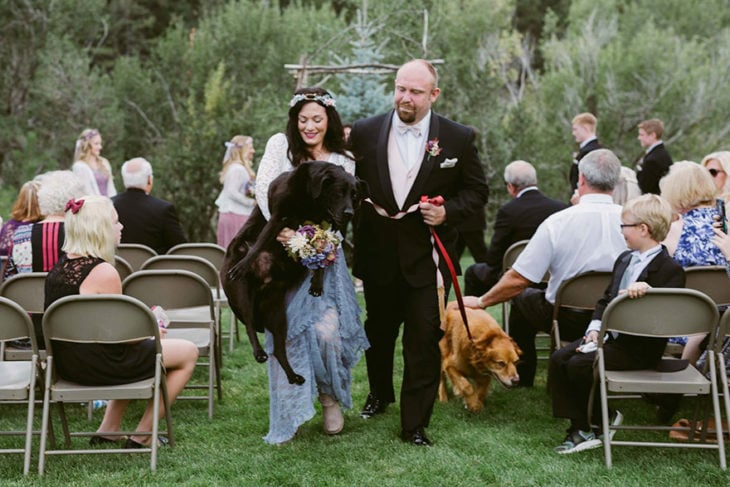 dos personas cargando un perro